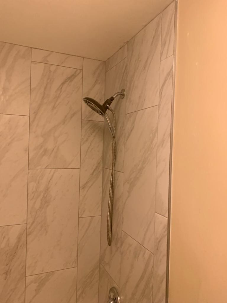 Tiled shower wall with a handheld shower head