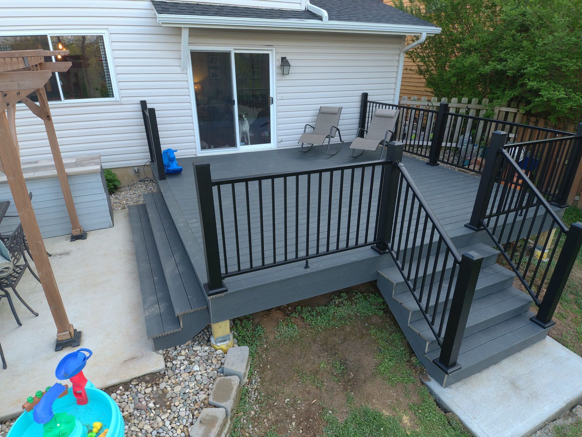 Gray deck with black railing and wide stairs